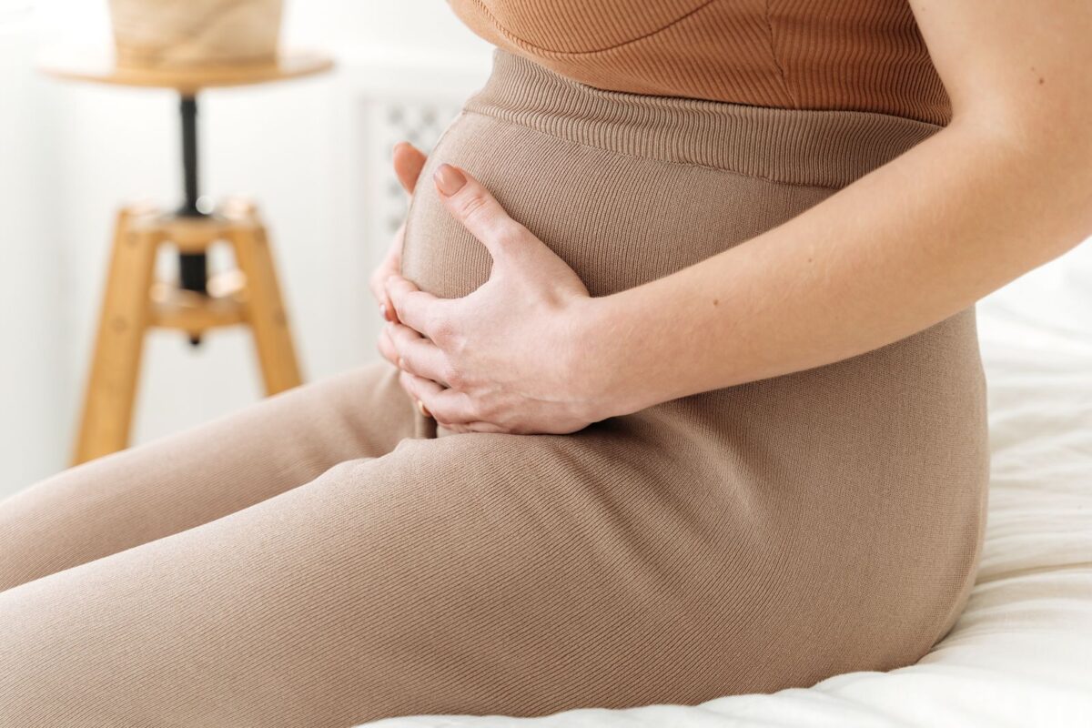 Phụ nữ đặt tay lên bụng dưới cảm nhận cơ thể sau chuyển phôi