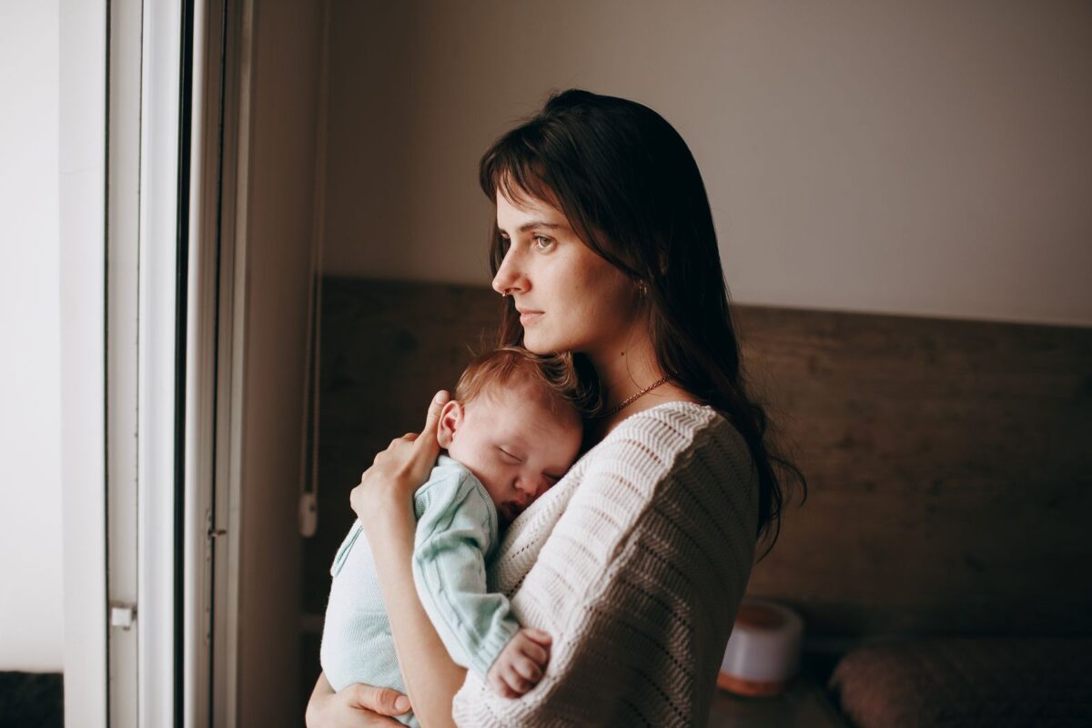 Người mẹ trầm tư bế con sơ sinh